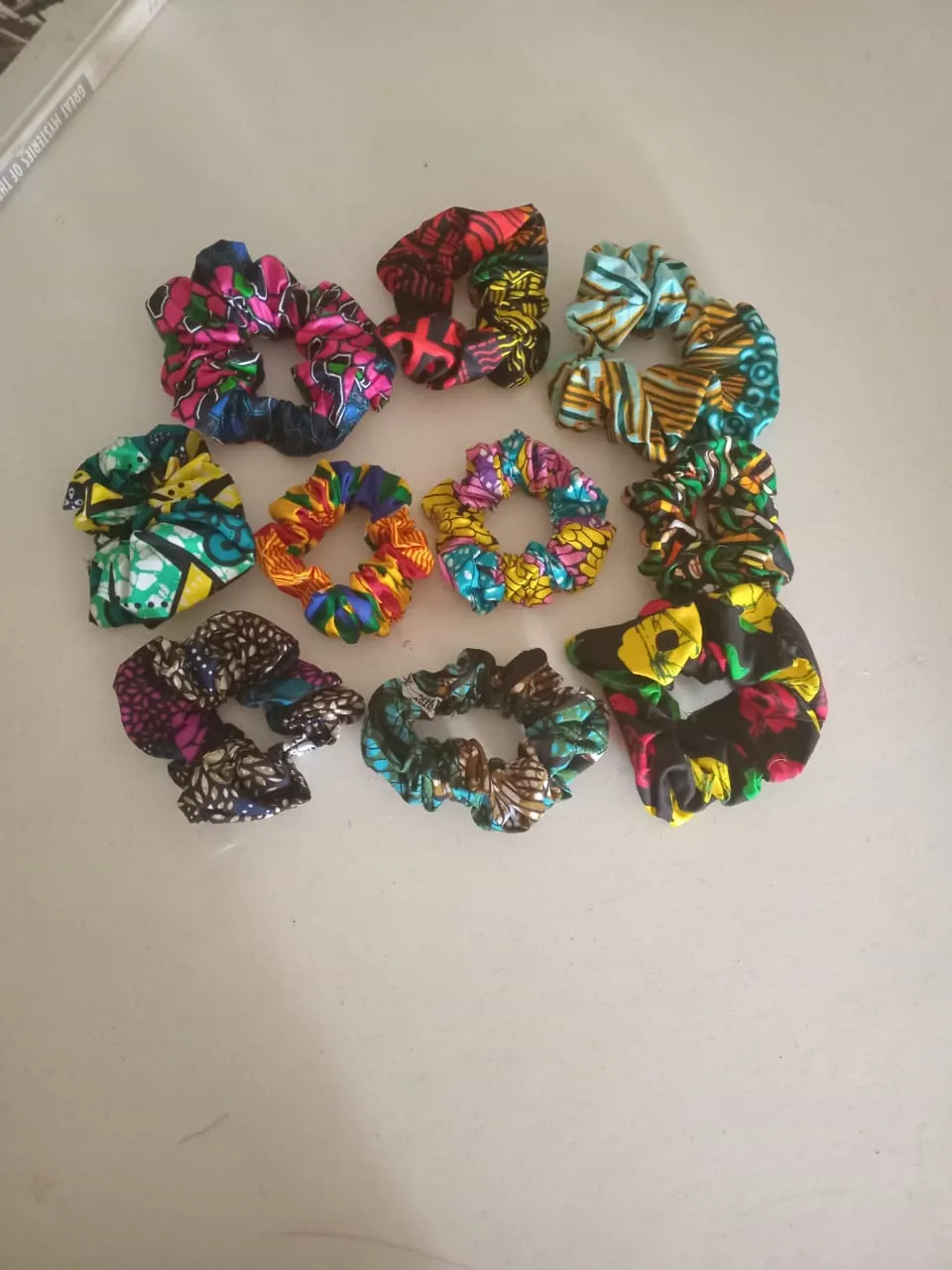 Eleven hair scrunchies sewn from African-print fabrics