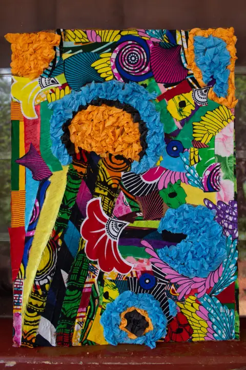 A collage of African-print fabric pieces with flowers of crumpled blue and orange paper
