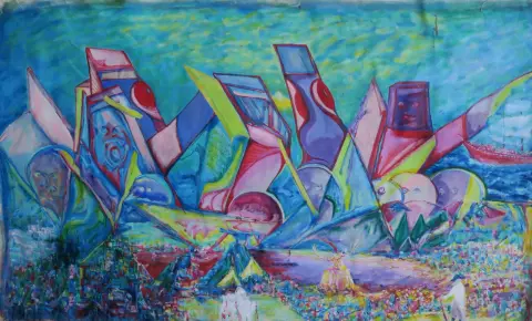 A large painting of angular shapes, faces and figures in blue, pink and yellow, with a ship and the sea behind