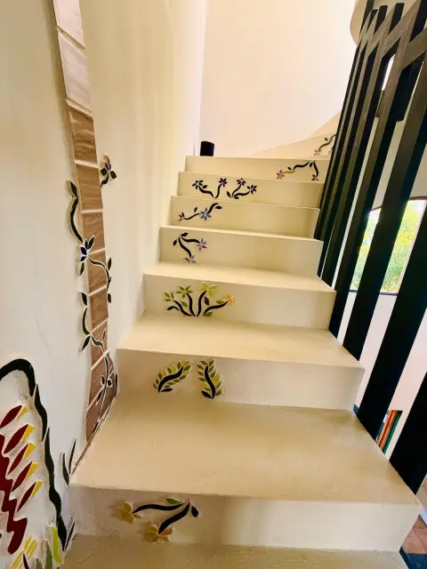 Mosaic vines and flowers in blue, purple, green and yellow on white stair risers